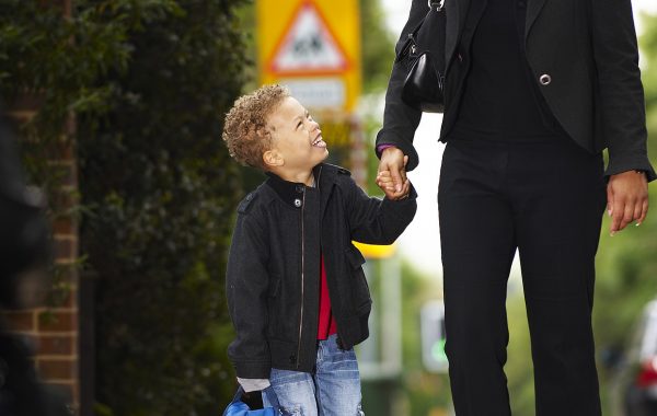 A child and an adult walking along a pavement