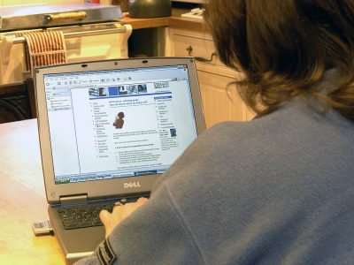 A woman using her laptop to look at NHS Direct website