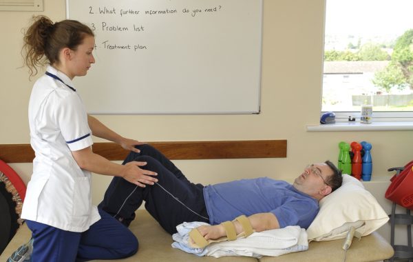 A physiotherapist helping a patient exercise