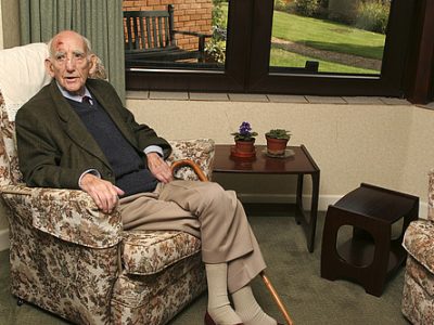 An older man sitting in a care home