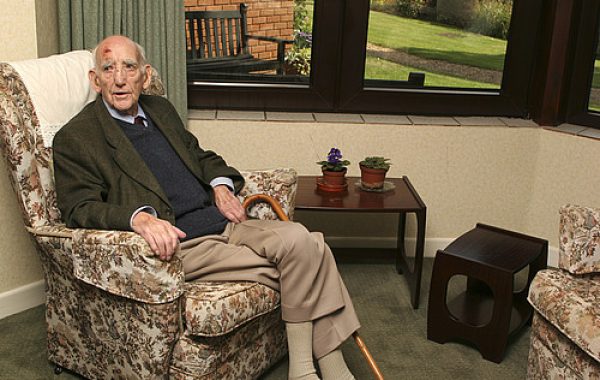 An older man sitting in a care home