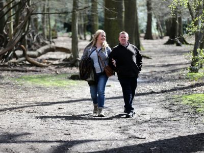 A couple walking in a wood. Image credit: World Obesity Federation