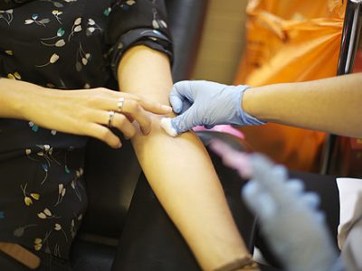 A woman is getting blood taken for a routine test