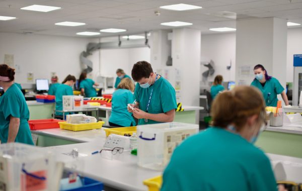 NHS workers in face masks at a workstation