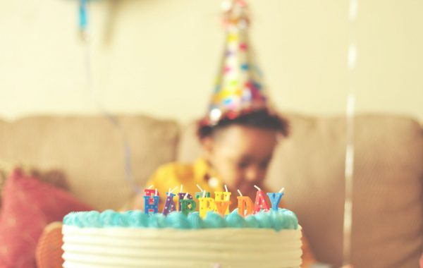 A birthday cake with a child in the background
