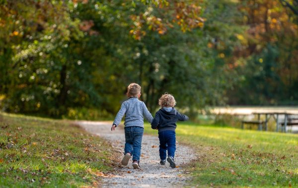 Two small children walk along a path