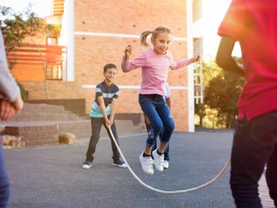 Children playing with a skipping rope in a city street