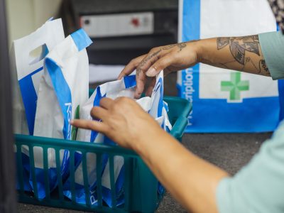 A pharmacy worker organises a basket of prescriptions