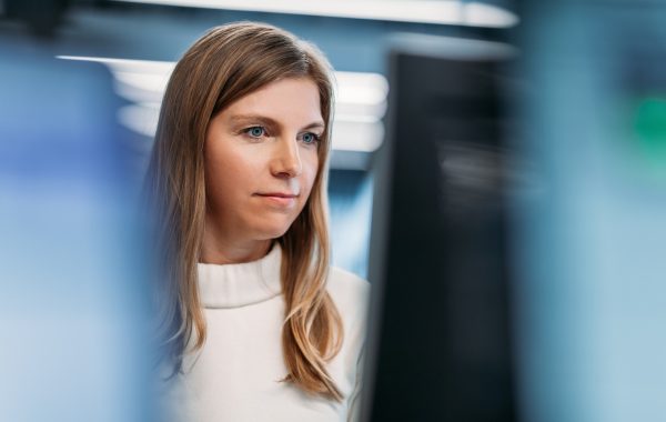 A woman looking at a computer monitor