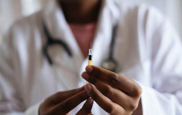 Close up view of healthcare professionals hands as they hold a filled syringe