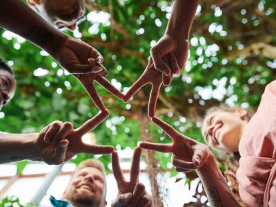 A group of children is holding their hands together in the victory sign