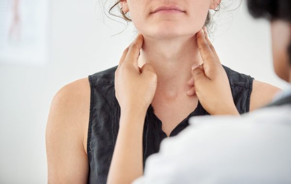 A doctor is checking a patient's neck