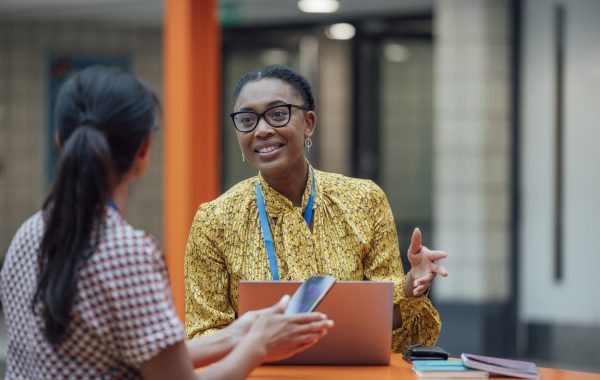 A worker wearing a lanyard in discussion with colleagues