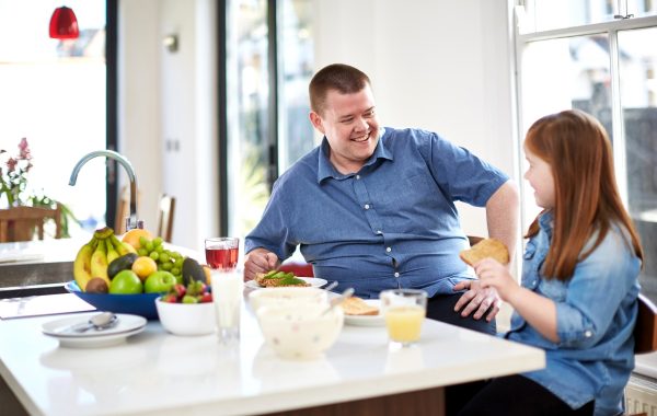 A father and daughter chatting in a kitchen