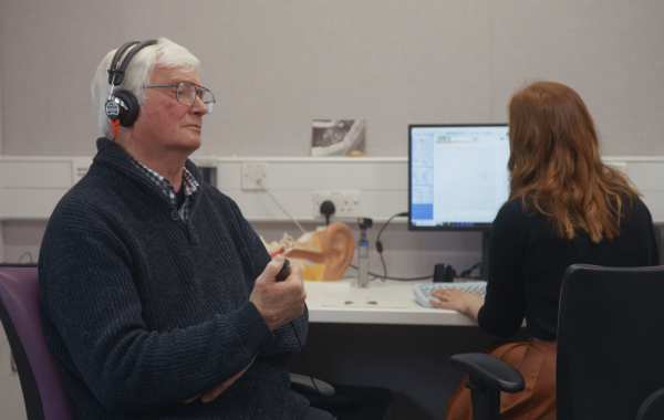 A patient has their hearing tested in a still from the video