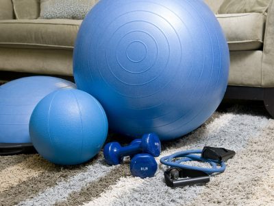 A set of home exercise equipment is laid out in front of the sofa