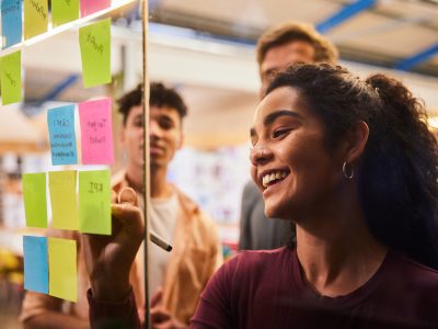 Young people write on post it notes during a workshop