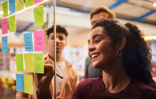 Young people write on post it notes during a workshop
