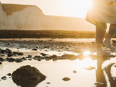 Reflection of a person walking along a shoreline