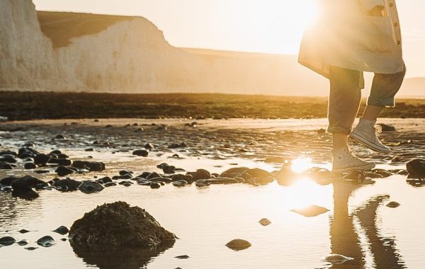 Reflection of a person walking along a shoreline