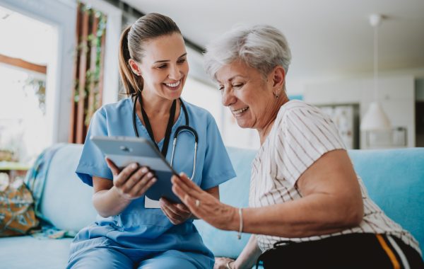 A healthcare professional with a patient in their home