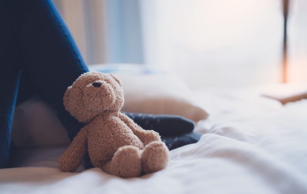 A teddy leaning against a play tent